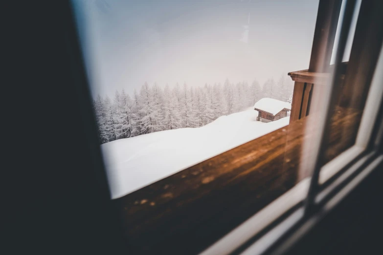 the open door to a snowy hill and a cabin