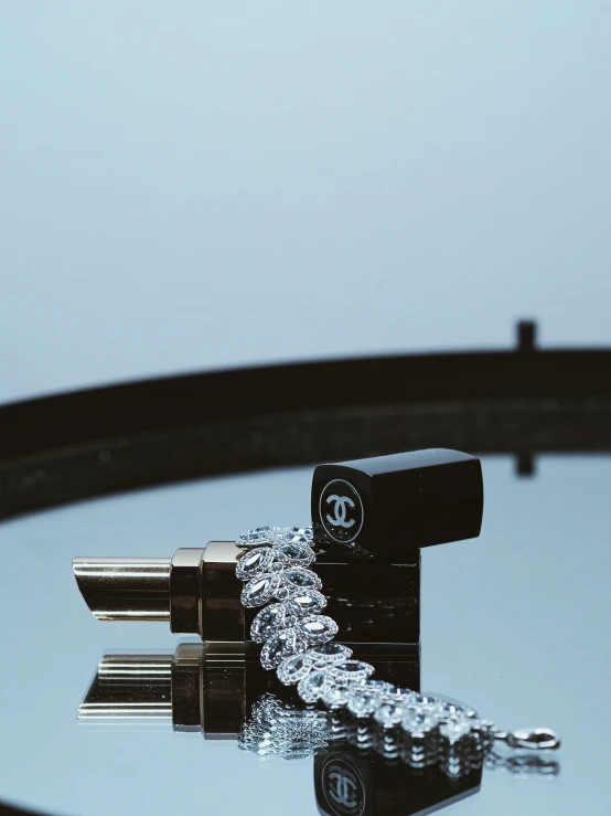 a chanel perfume bottle laying in water on top of a mirrored surface