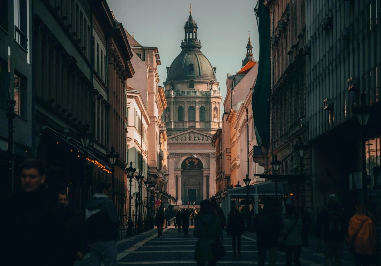 people are walking through an alley lined with buildings