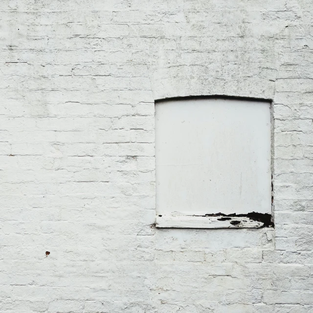 a window on a brick wall, with dirt marks around it