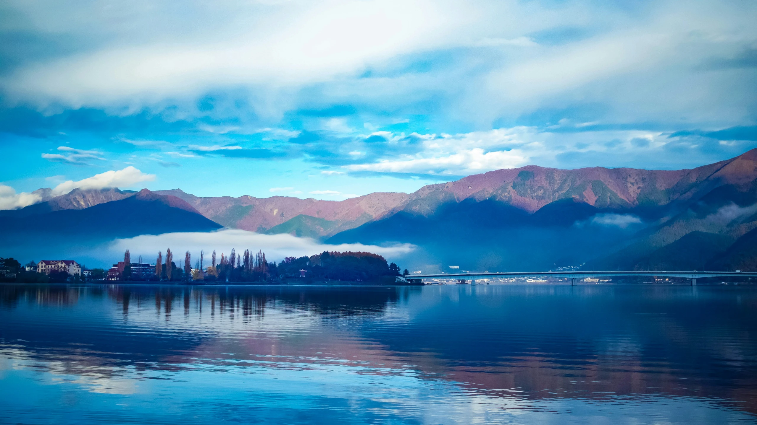 a boat travels on the water surrounded by mountains