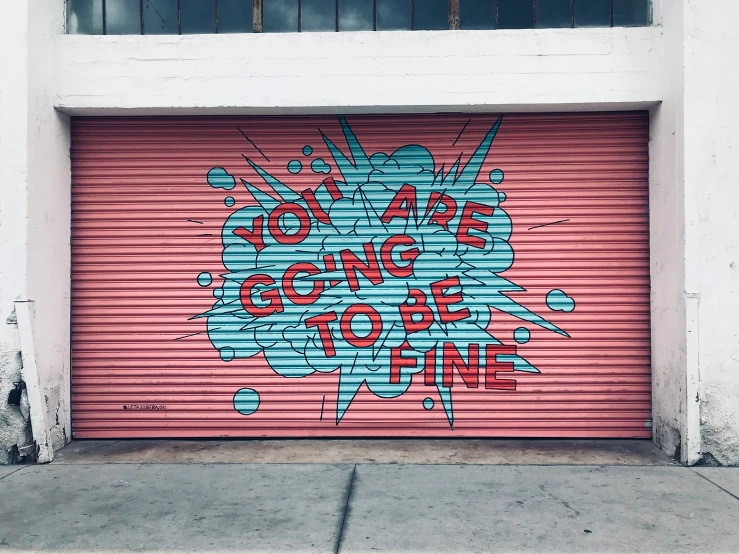 a garage door covered in graffiti on the side of a building