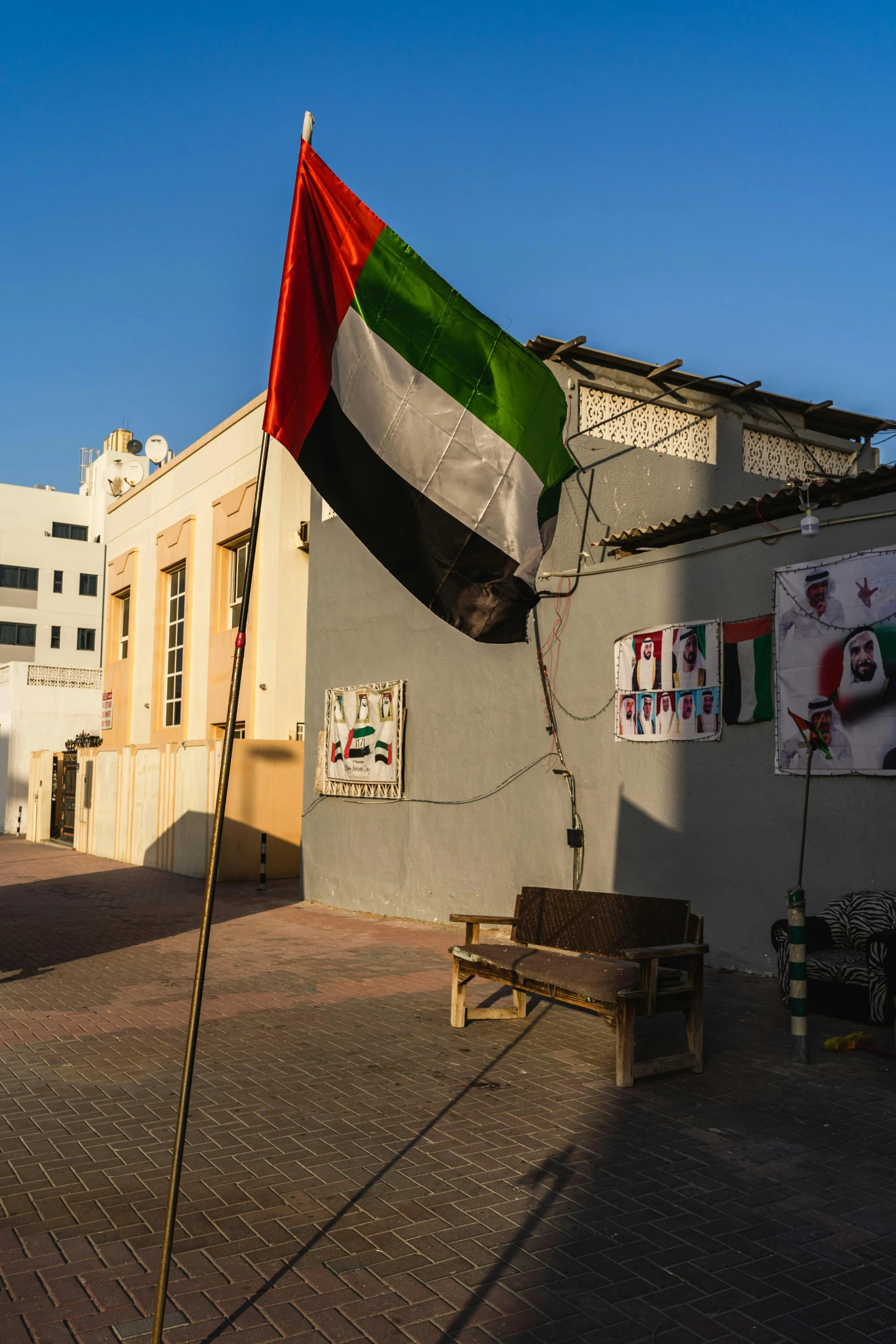 a red white and green flag flying on the street