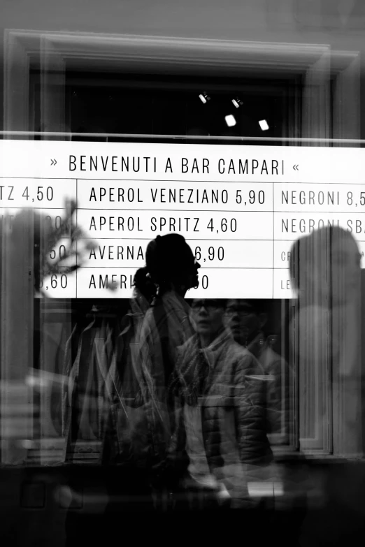 people standing in front of a store window with their reflection