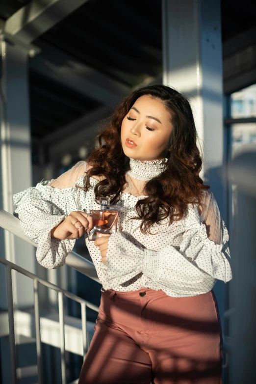 a woman is posing holding a glass of wine