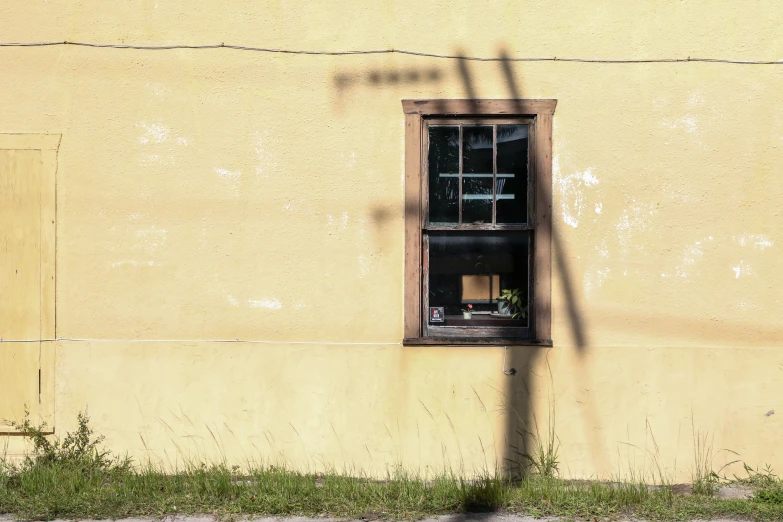 a window sitting on the side of a yellow building