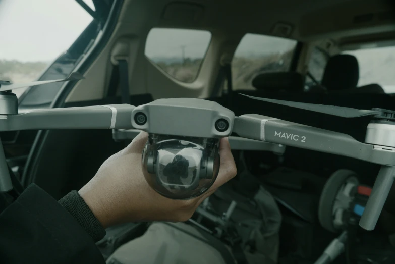 a man holding a small vehicle camera