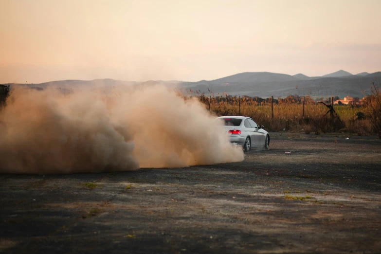 two cars that are driving through dust