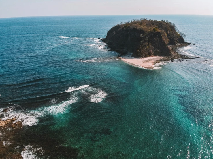 a small island sits in the middle of the ocean