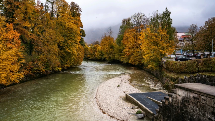 river and steps in city park with autumn colored trees