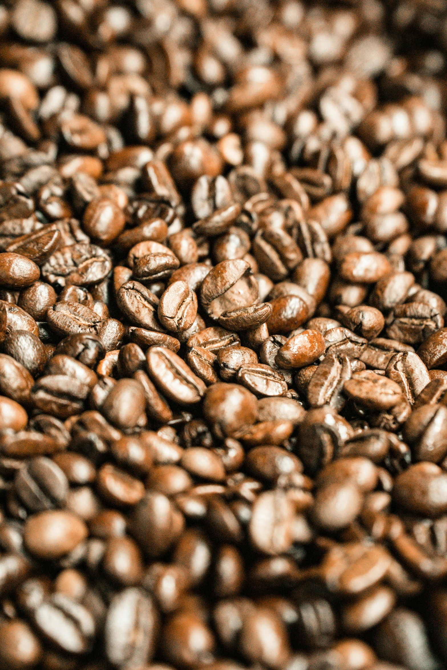 a large pile of coffee beans next to a white plate