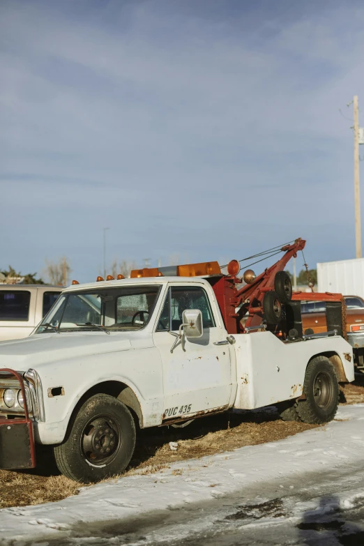 an old truck parked in a yard filled with snow