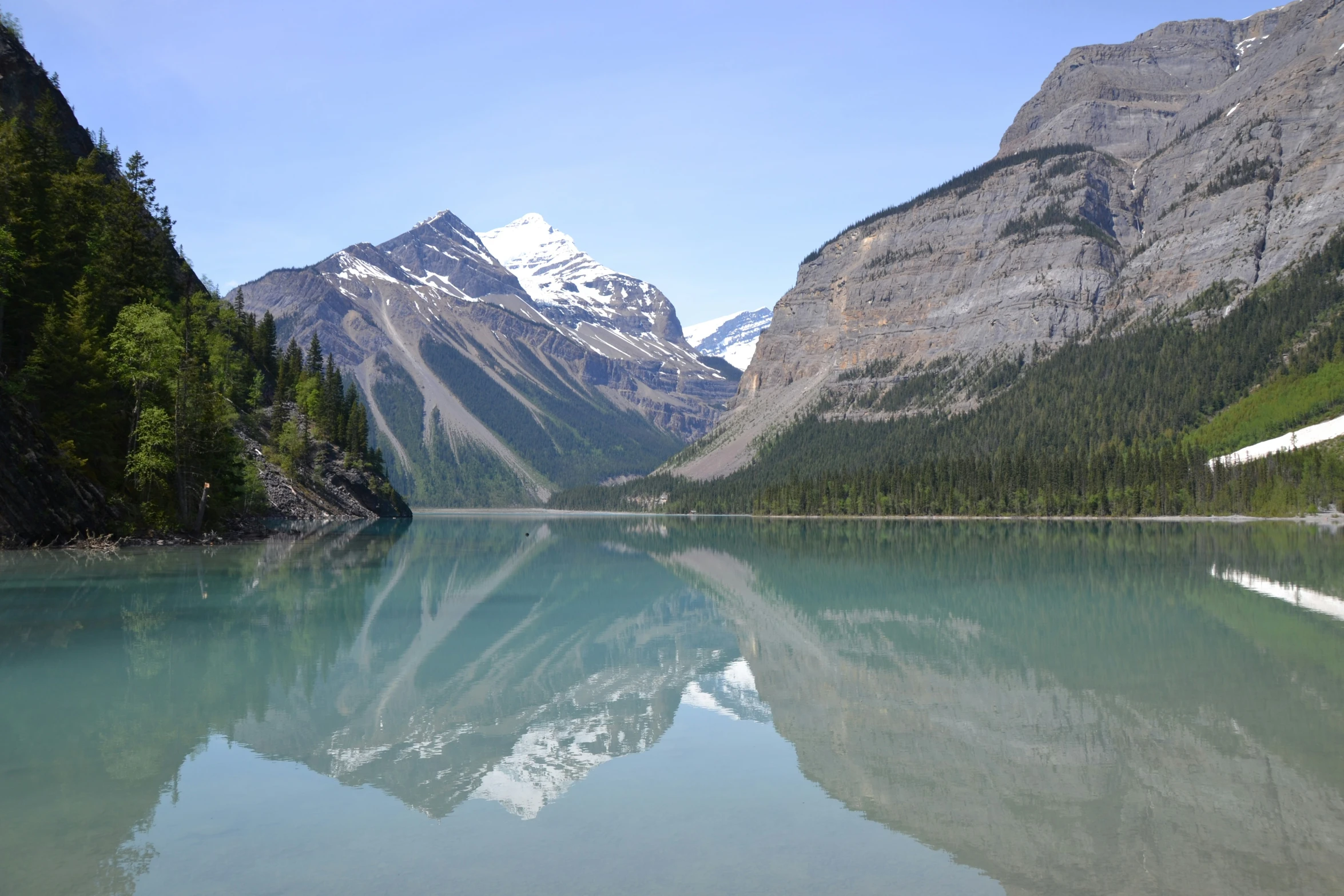 a clear lake surrounded by trees and mountains