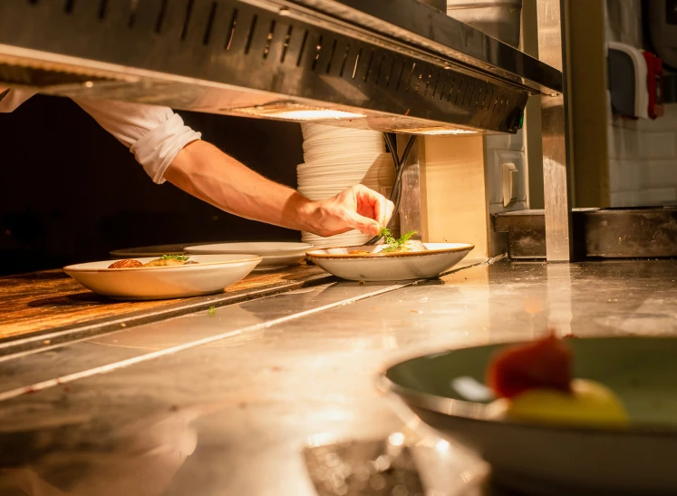 a man is reaching for some food in a kitchen