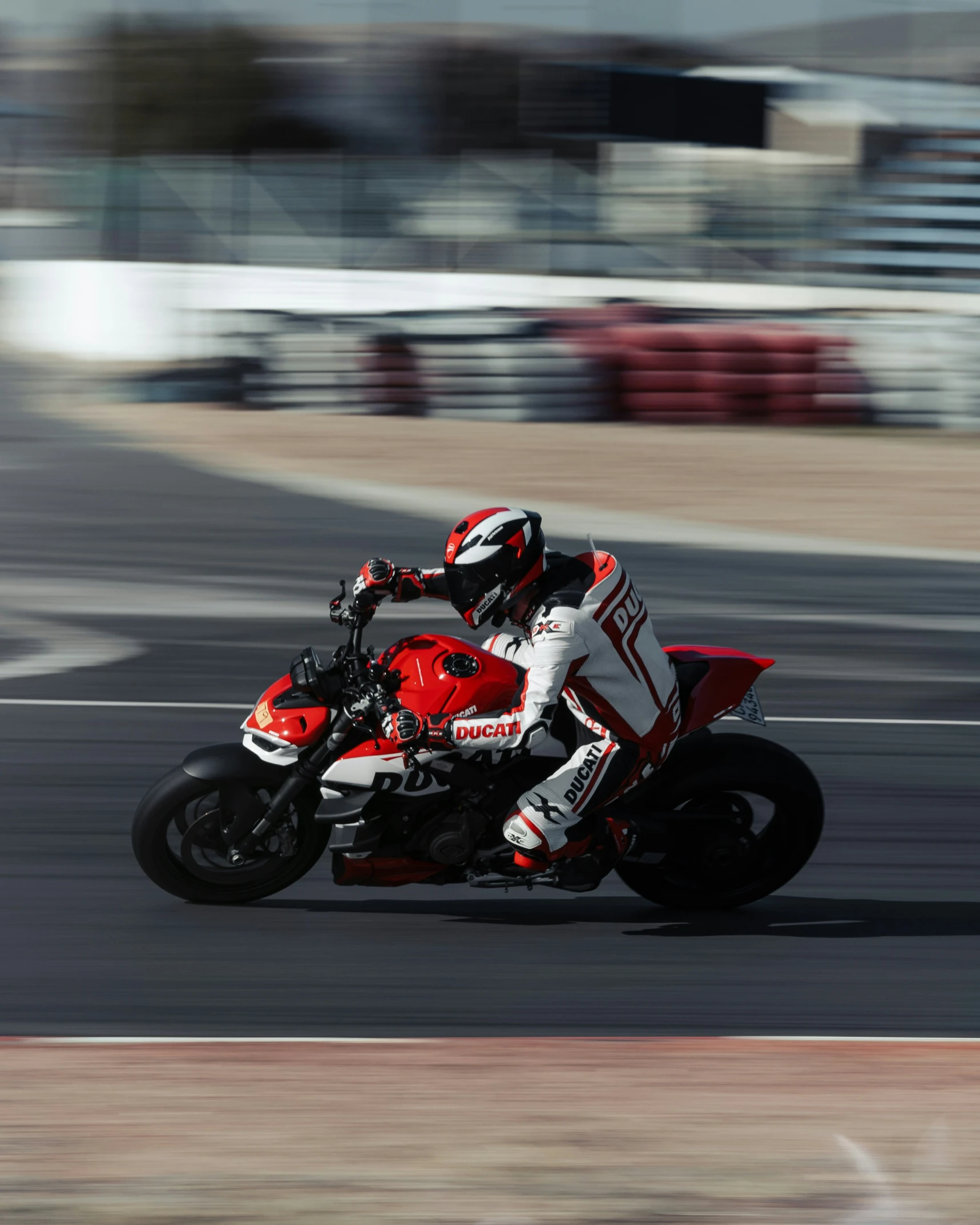 man on red and white motorcycle taking part in a race