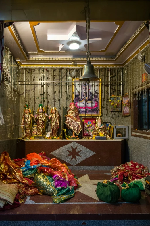 various colorful cloths laying out on the ground in front of a statue