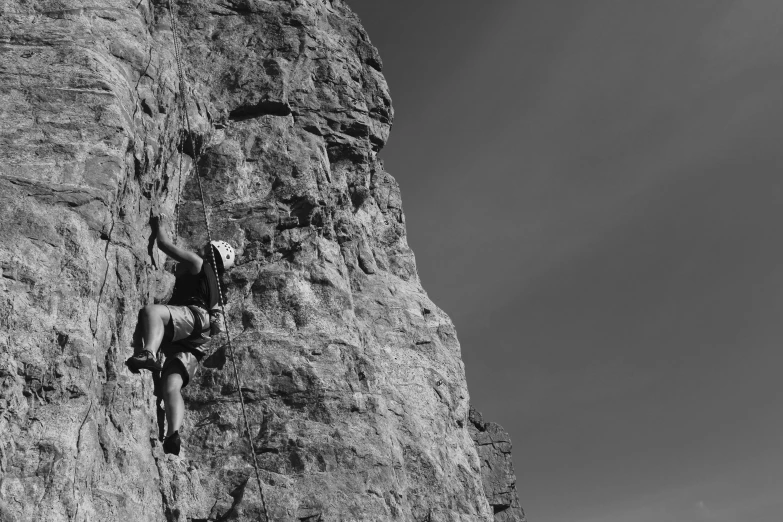 a man climbing up the side of a rock cliff