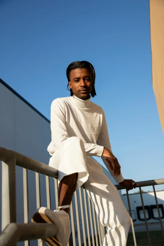 a woman sitting on top of a balcony, wearing white clothing