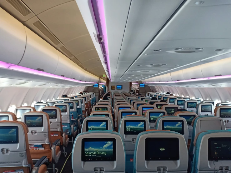an airplane with several rows of seats and multiple monitors
