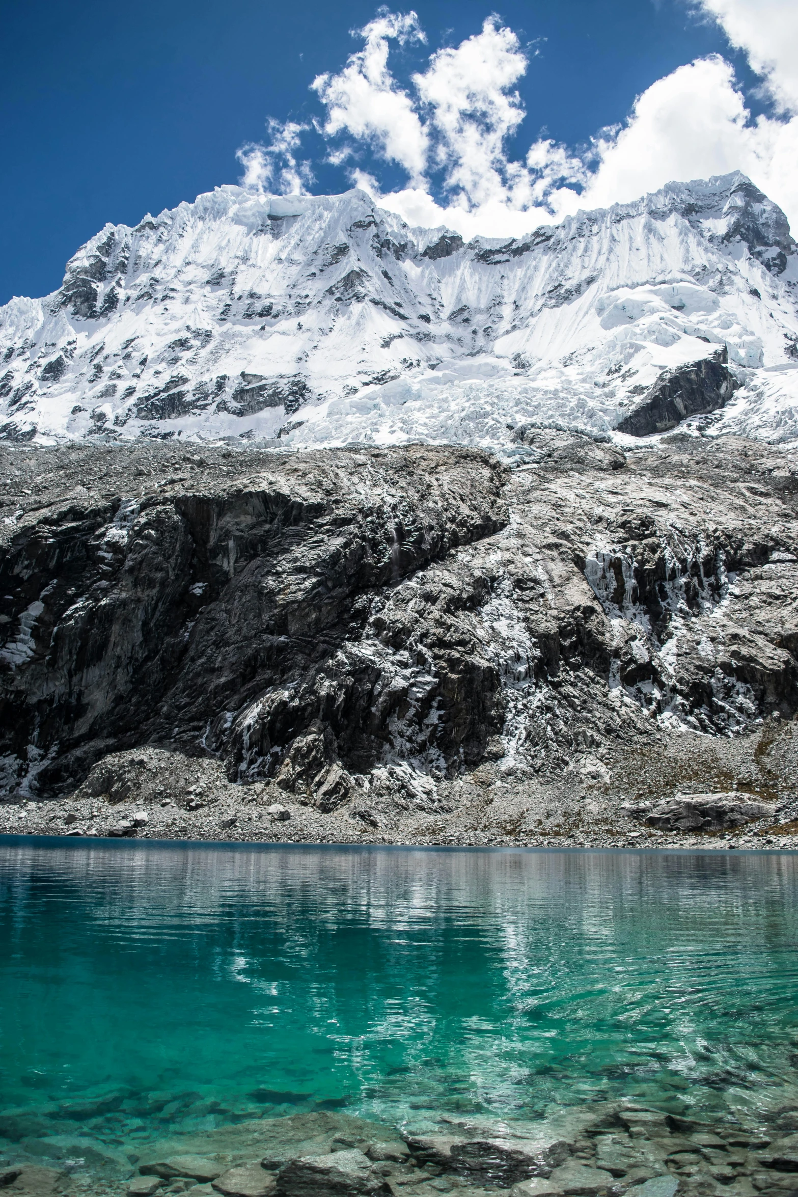 a large snow capped mountain on the edge of a body of water