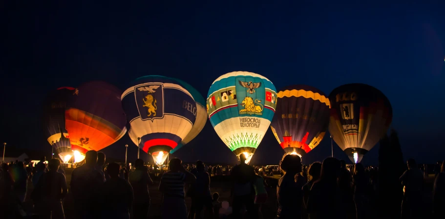 a bunch of balloons are being lit up by some lights