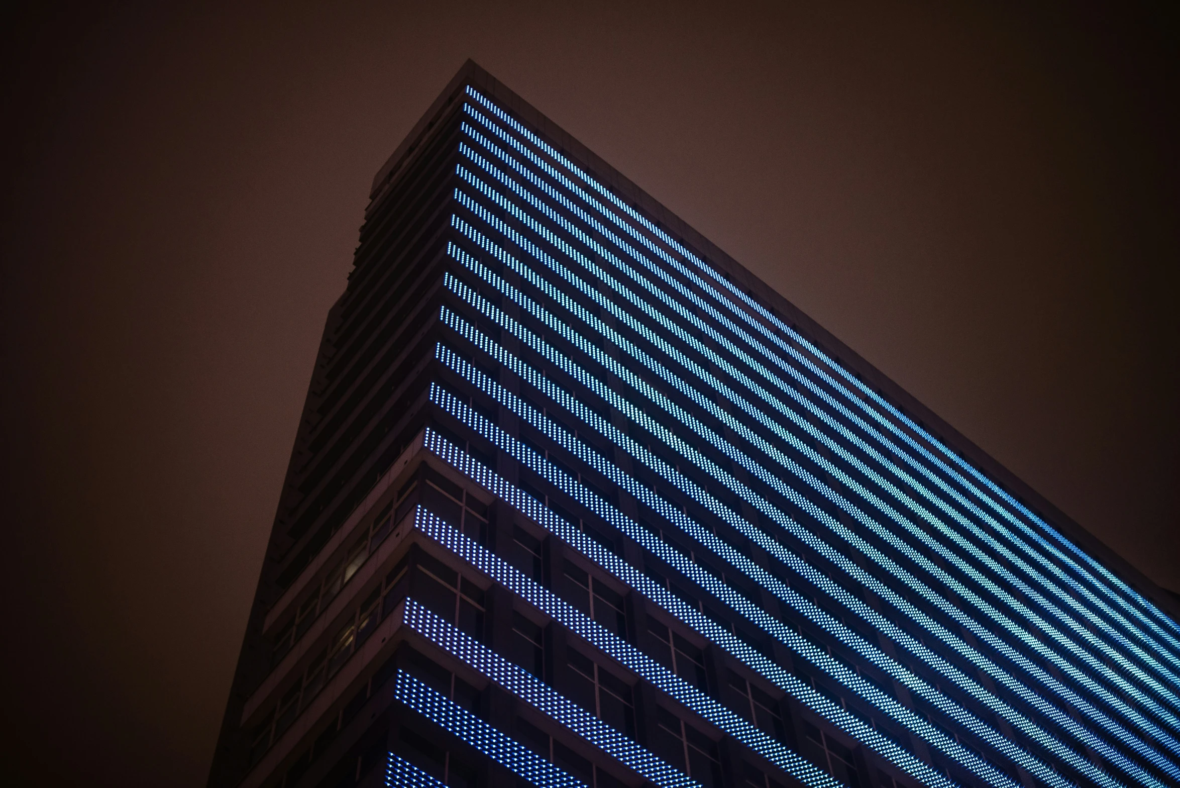 the tall building is lit with blue light