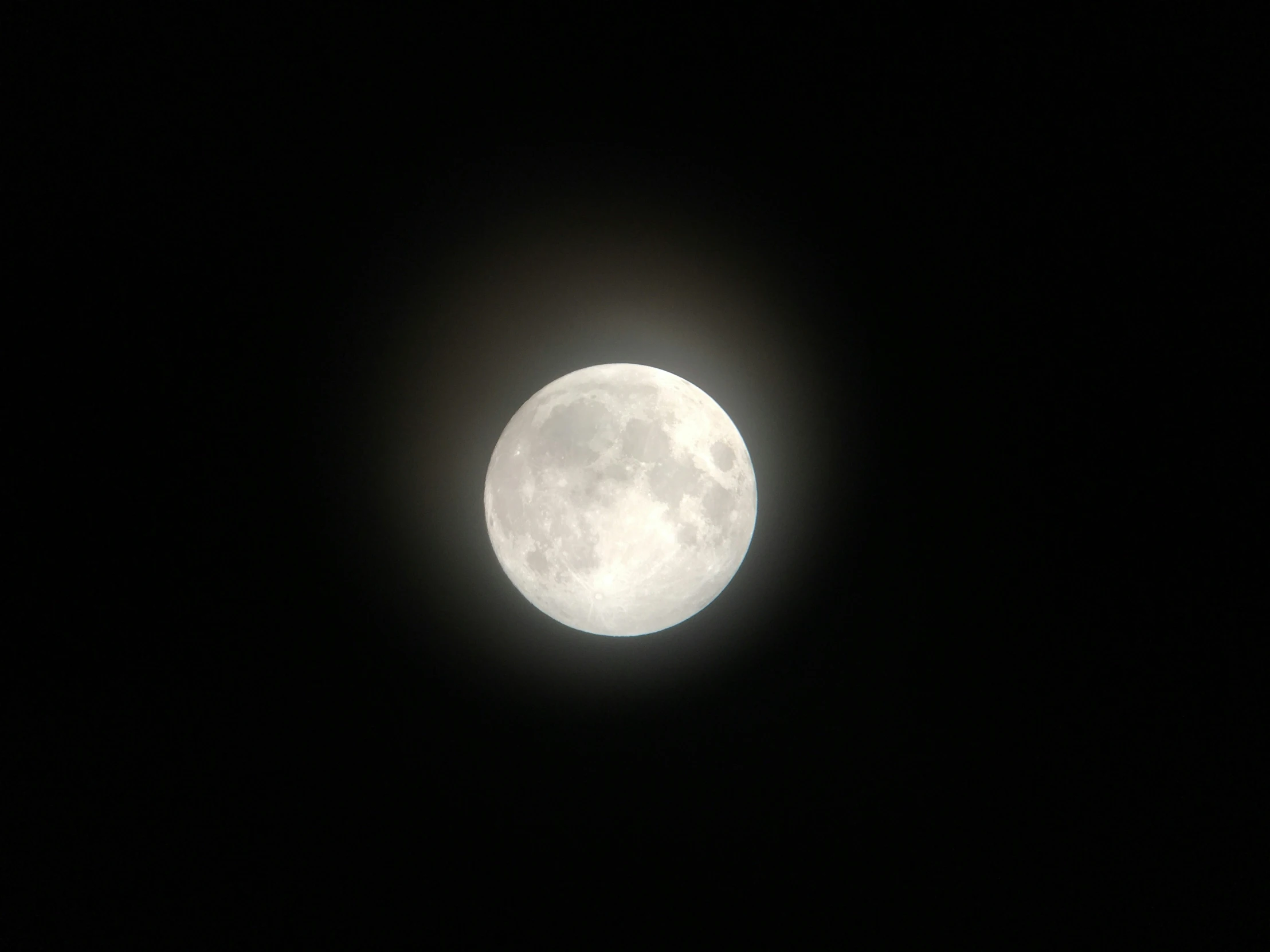 the full moon on a dark night is shown from above