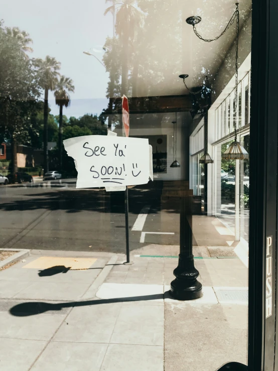 a sidewalk corner with a street sign and storefront