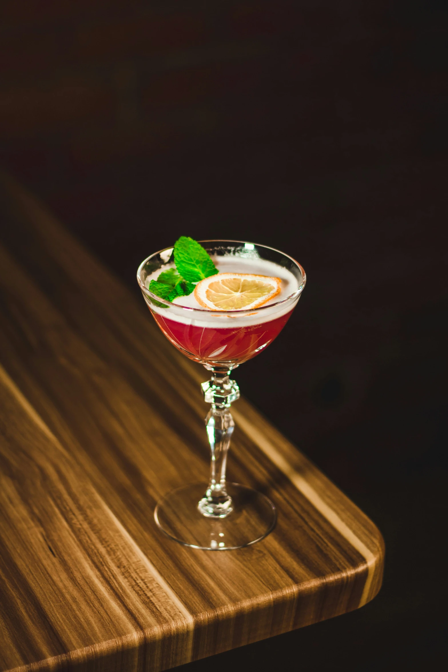 a glass filled with cocktail on top of a table