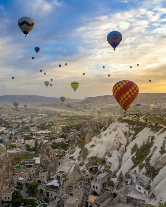  air balloons flying in the sky near buildings