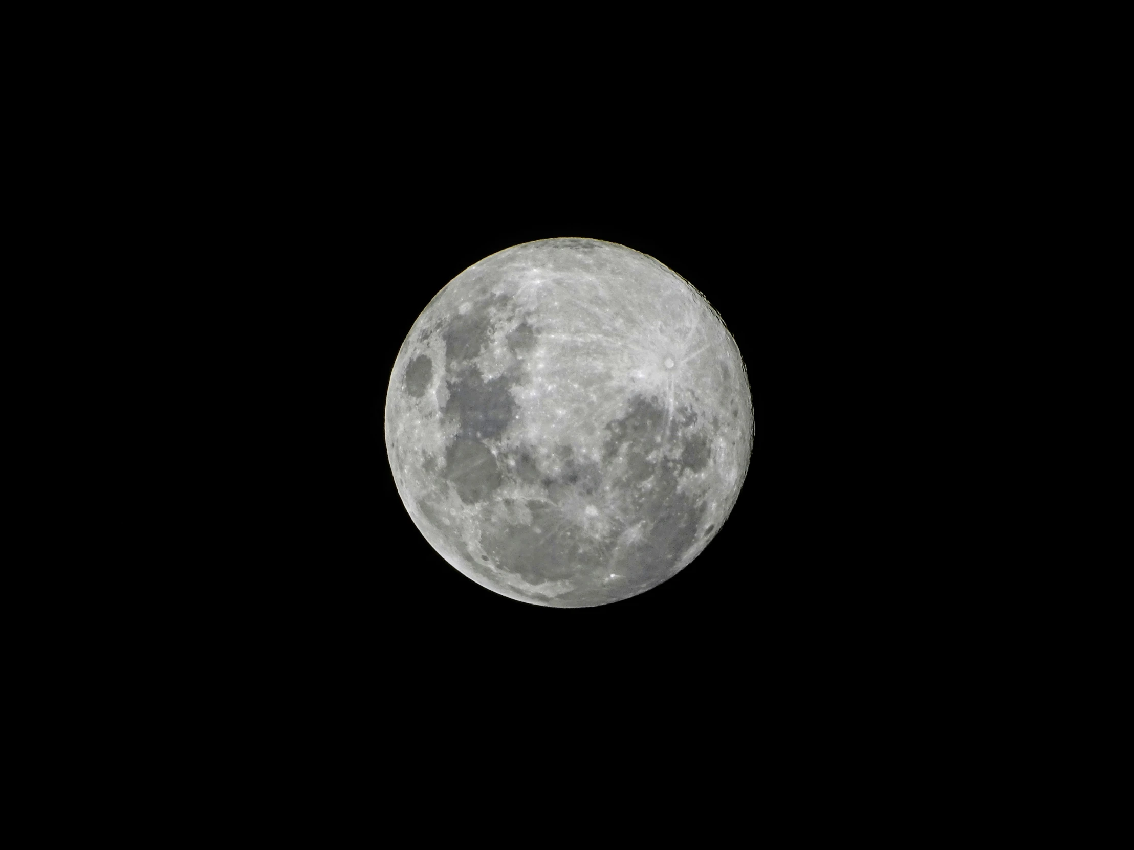 a plane flying past a large moon in the sky