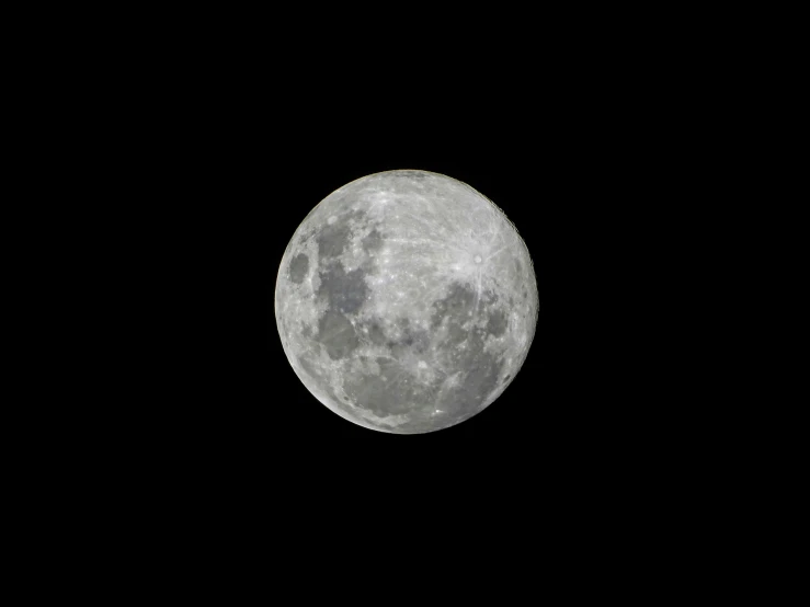 a plane flying past a large moon in the sky