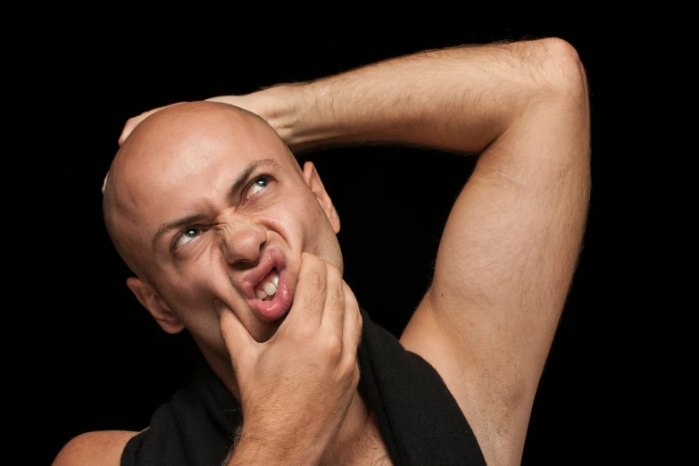 bald man with tongue out in a black shirt