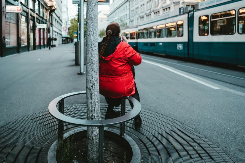 a woman is standing by a pole and taking a po