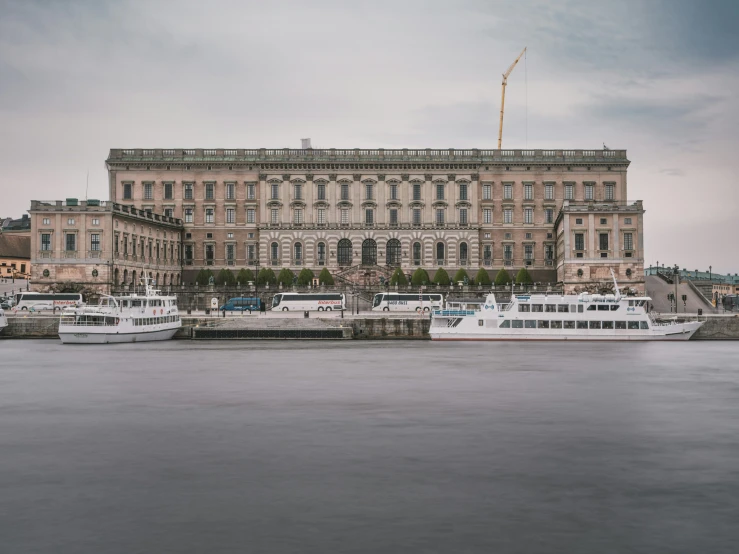 a large brown building with some boats next to it