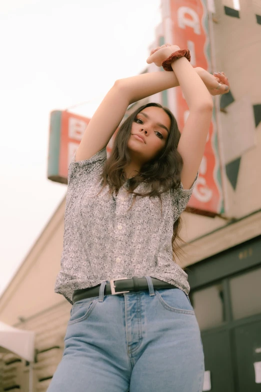 a girl stands in the middle of her arms up