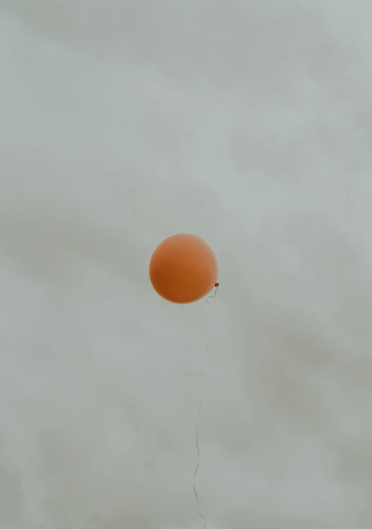 a balloon is flying across the sky in a cloudy sky