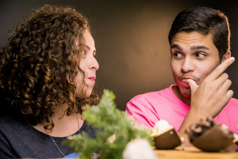 a man and woman in pink shirt with food on a table