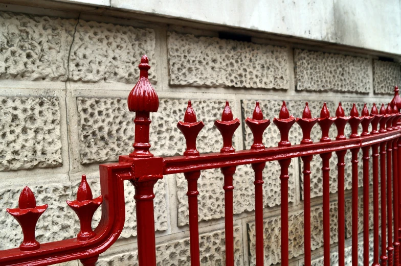 red rails and a brick wall are used as a fence