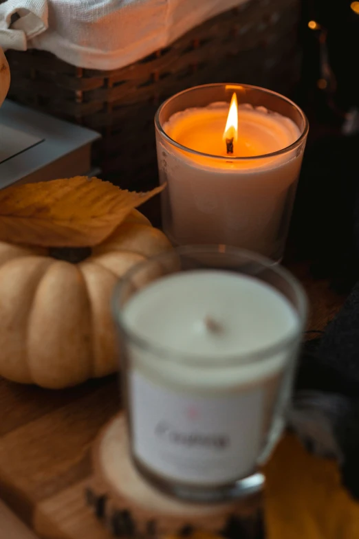 a candle and a basket of pumpkins