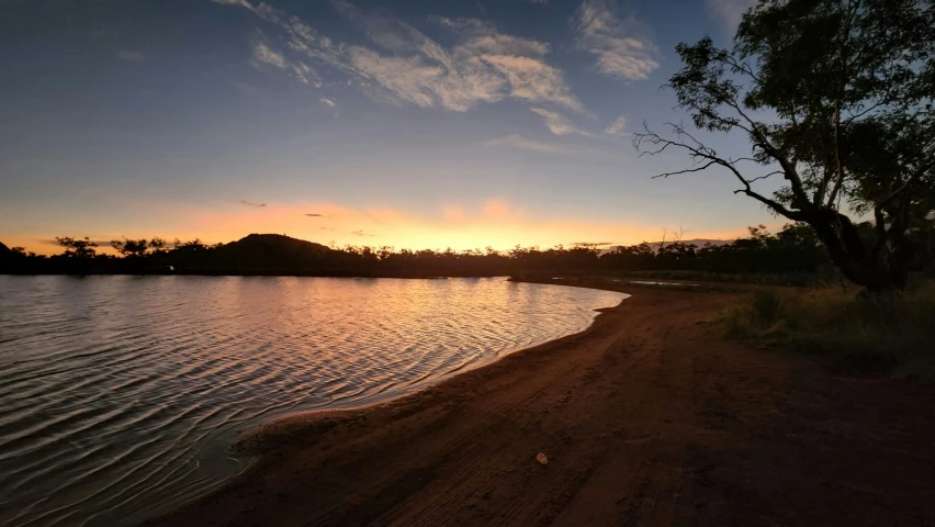 a large body of water at sunset in the distance