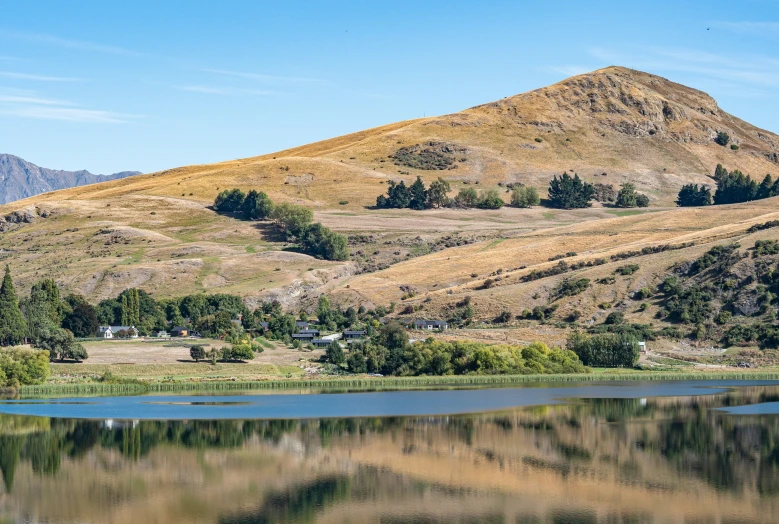 mountains near water and green field on a sunny day