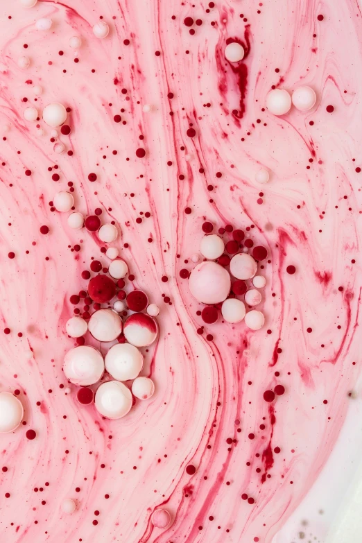 a pink substance with lots of white balls