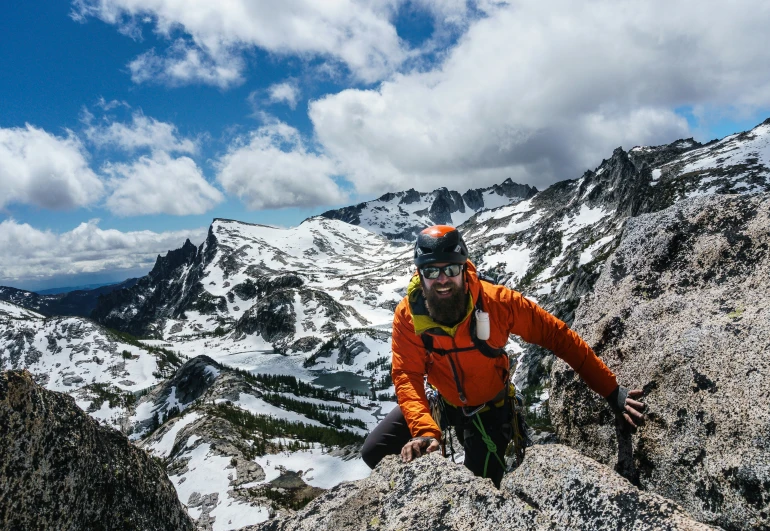 a person standing on a rock with mountains in the background