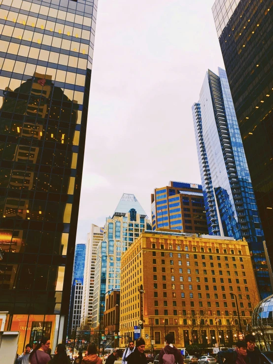 people crossing a street with tall buildings in the background