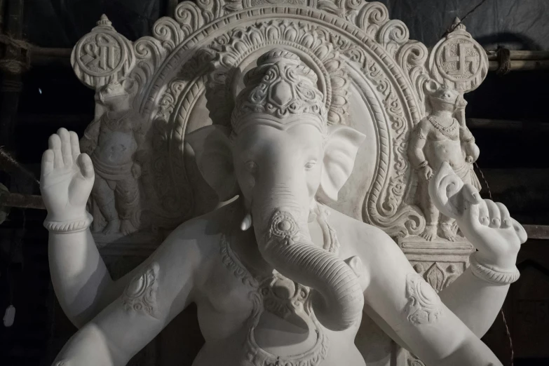 the statue of ganesha sits in a dark room