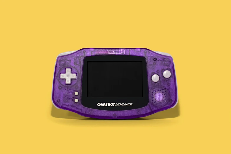a small purple gameboy that is sitting on top of yellow