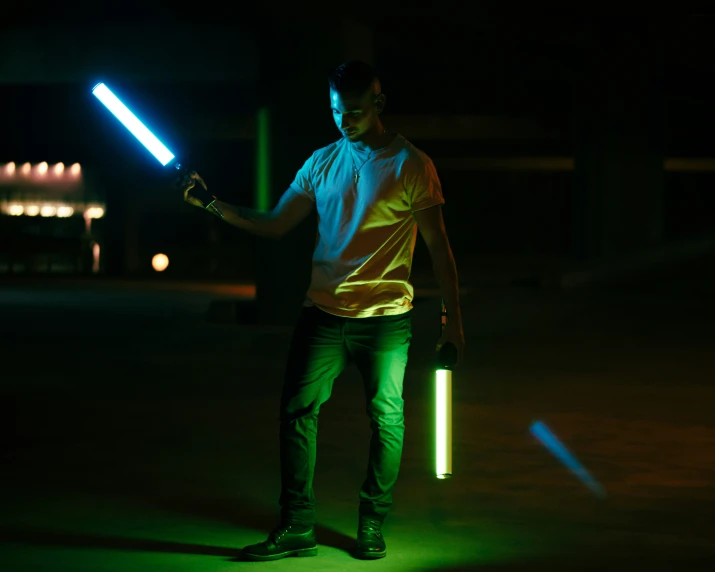 a young man with his arm raised and a light saber in hand is standing in the dark