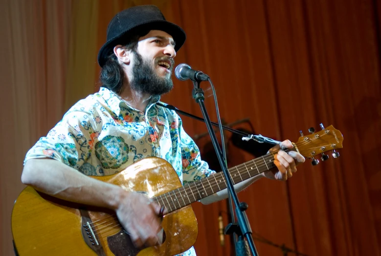 a man is singing into a microphone while playing the guitar