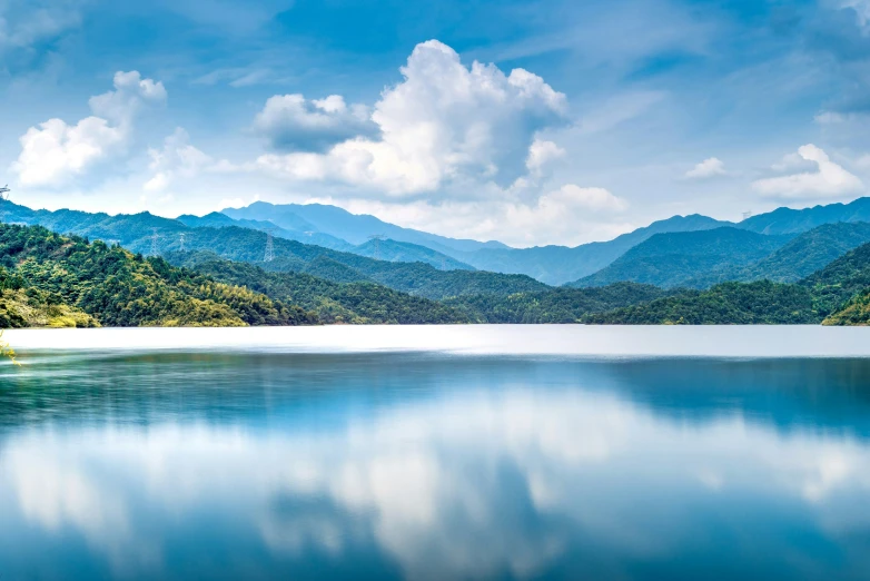 the blue water has mountains in the background